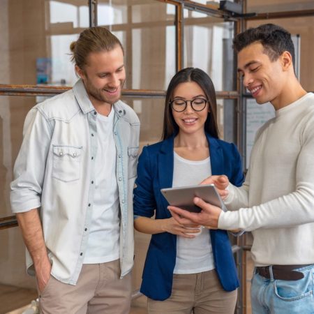 three-young-business-professionals-standing-together-and-discussing-over-business-report.jpg